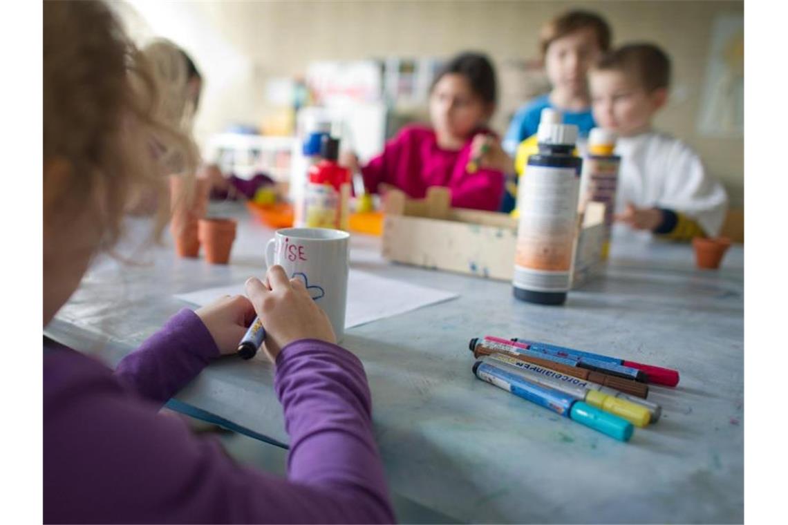 Grundschüler und Grundschülerinnen basteln in einem Hort. Foto: picture alliance/Uwe Anspach/dpa/Symbolbild