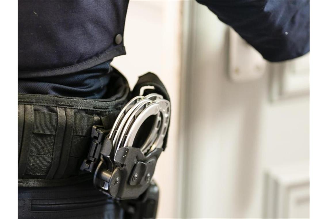 Handschellen sind an einem Gürtel eines Justizvollzugsbeamten befestigt. Foto: Frank Molter/dpa