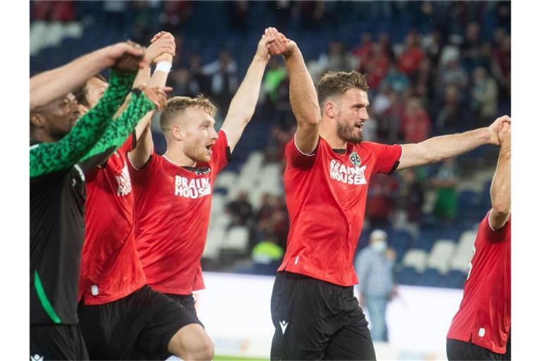 Hannovers Siegtorschütze Hendrik Weydandt (M) feiert den Sieg seiner Mannschaft. Foto: Julian Stratenschulte/dpa