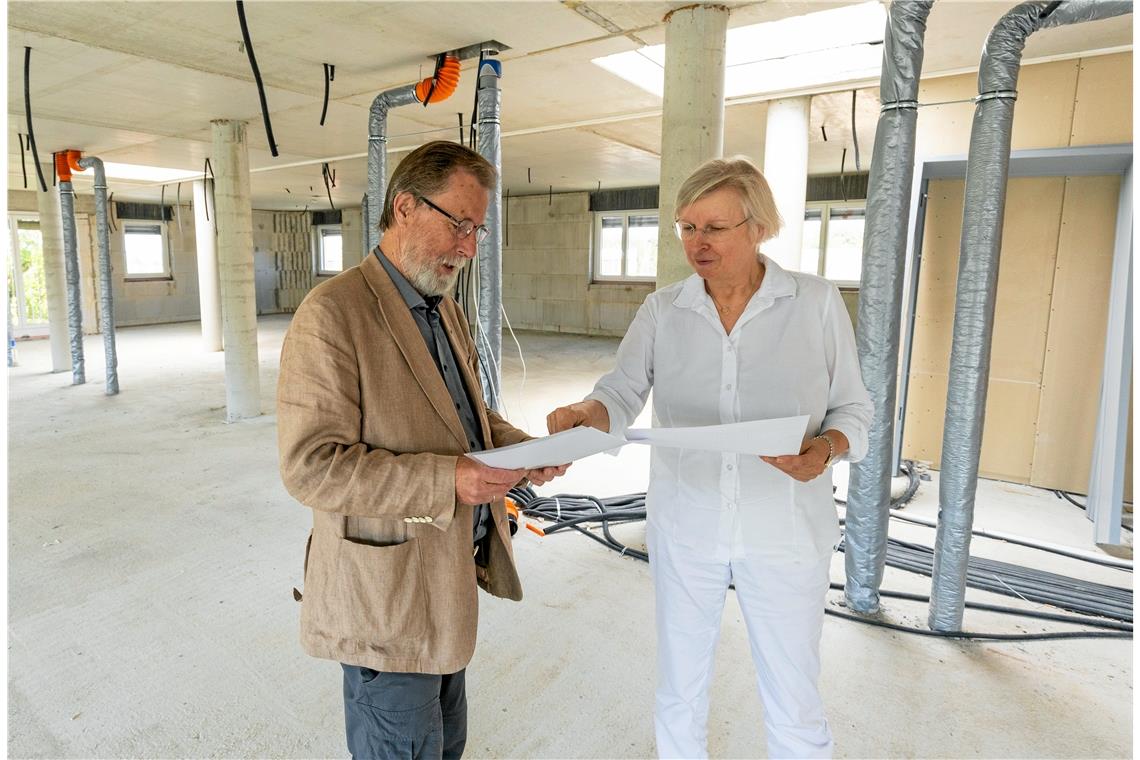 Heinz Franke und Ute Ulfert vom Vorstand der Hospizstiftung Rems-Murr studieren die Baupläne für die Erweiterung. Das oberste Stockwerk, das noch ein Rohbau ist, soll ausgebaut werden. Zusätzlich ist ein Aufbau auf dem Dach geplant. Foto: Alexander Becher