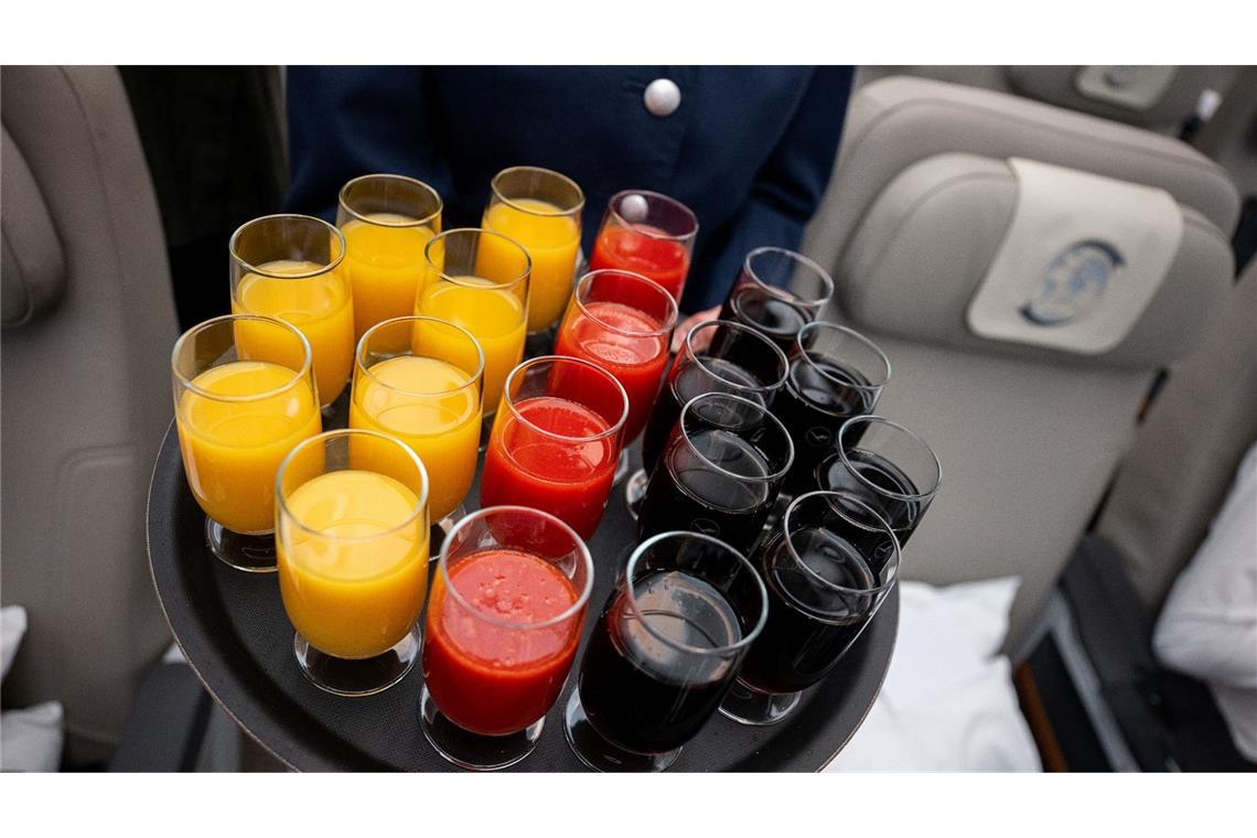 Heute muss die deutsche Nationalmannschaft wieder in der Europameisterschaft ran. Eine Flugbegleiterin trägt anlässlich des Spiels ein Tablett mit Orangensaft, Tomatensaft und Cola durchs Flugzeug.