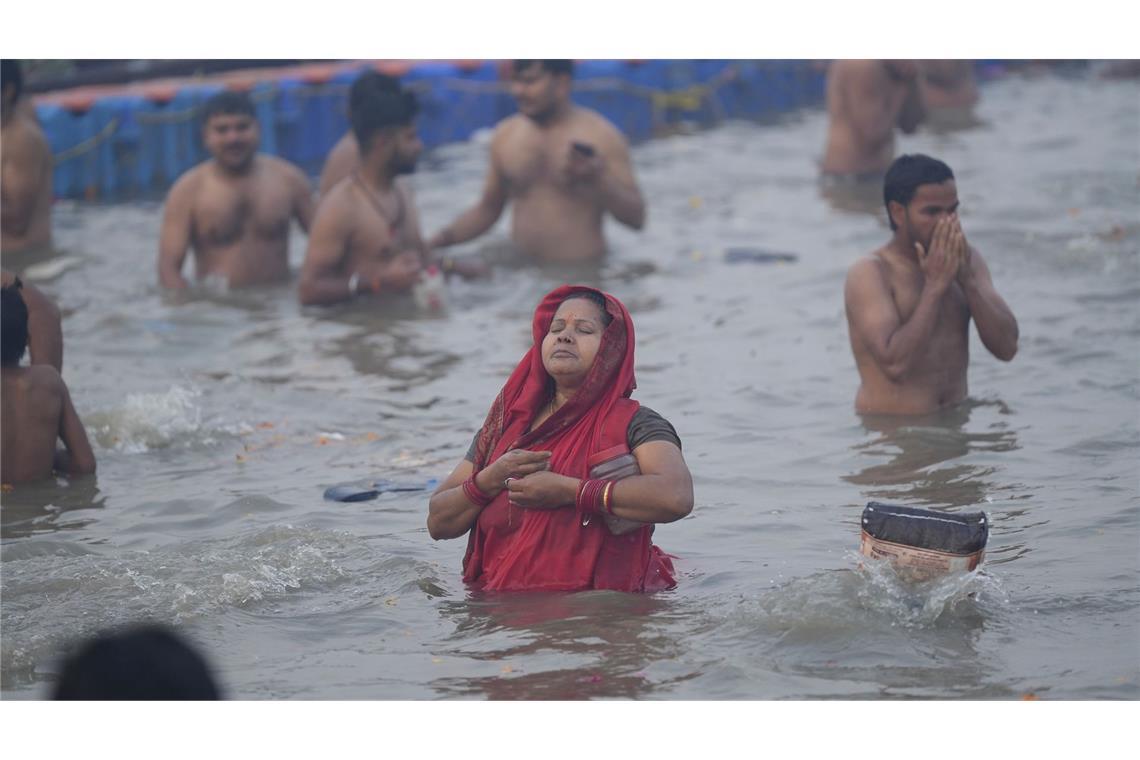 Hinduistische Gläubige nehmen am Neumondtag während des Maha Kumbh Mela Festivals ein heiliges Bad am Ufer des Sangam.