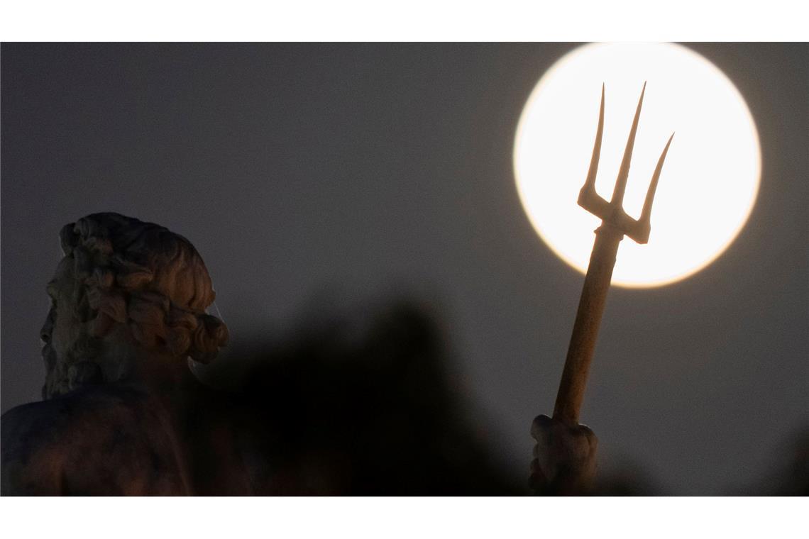 Hinter der Poseidon-Statue in Kopenhagen ist am Himmel ein großer Vollmond zu sehen.