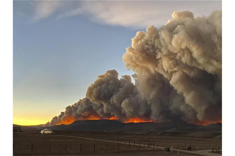 Hinter einem Bergkamm im Norden von Colorado steigen über dem Schein des Feuers die Rauchwolken auf. Foto: Jessy Ellenberger/AP/dpa