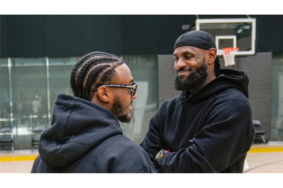 Historisches in der NBA: Los Angeles Lakers Draft Pick Bronny James (l) und sein Vater, LeBron James, lachen zusammen als sie zur Pressekonferenz des NBA-Basketballteams in El Segundo, Kalifornien, kommen. Zum ersten Mal in der Geschichte der Liga spielen ab der nächsten Saison ein Vater und dessen Sohn in einem Team.