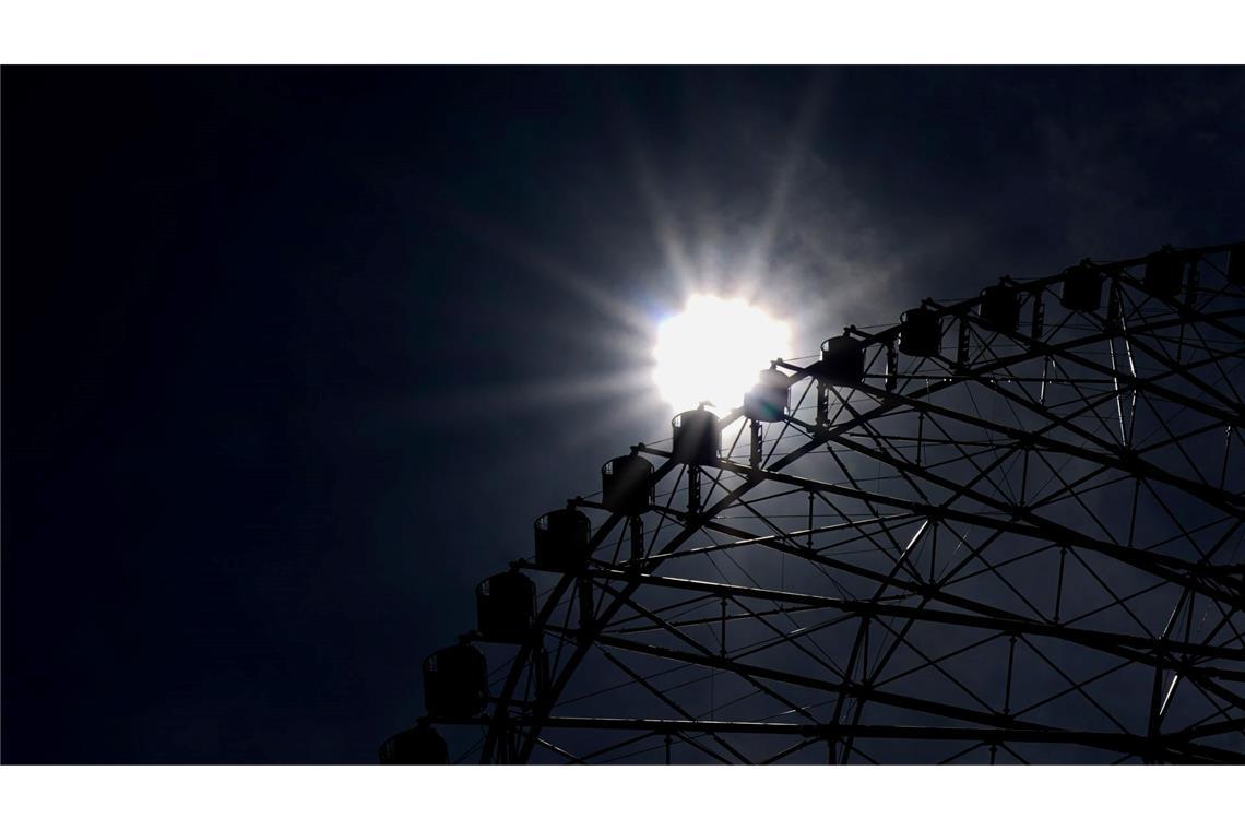 Hitze in Japan: Hinter einem Riesenrad ist die gleißende Sonne bei weit über 30 Grad im Kasai Rinkai Park in Tokio zu sehen