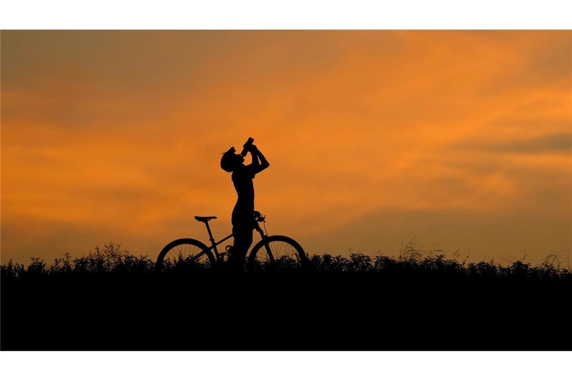 Hitze in Texas: Ein Radfahrer macht in der Abenddämmerung eine Trinkpause.