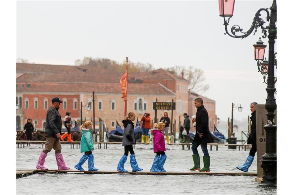 Klimatrend setzt sich fort: 2019 wohl zweitheißestes Jahr Hochwasser-Routine in Venedig: Touristen sind auf schmalen Stegen unterwegs. Foto: Luca Bruno/AP/dpa