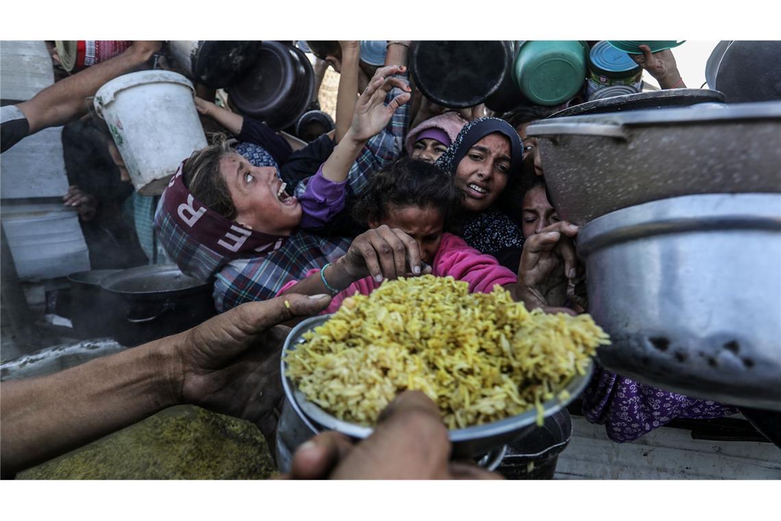 Hoffen auf Essen - Vertriebene Palästinenser stehen dicht gedrängt an, um Mahlzeiten von einer Wohlfahrtsorganisation zu  bekommen.