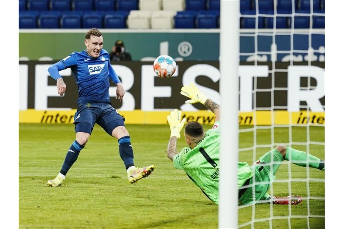 Hoffenheims David Raum schiesst an Augsburgs Torwart Rafael Gikiewicz vorbei das Tor zum 3:1. Foto: Uwe Anspach/dpa