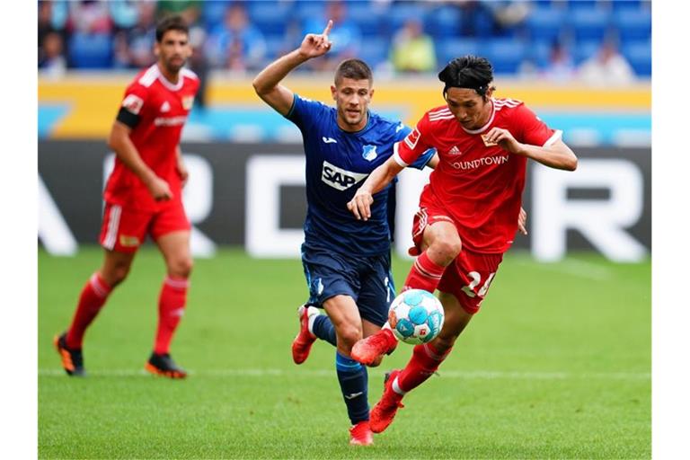 Hoffenheims Stürmer Andrej Kramaric und Unions Mittelfeldspieler Genki Haraguchi (r). Foto: Uwe Anspach/dpa