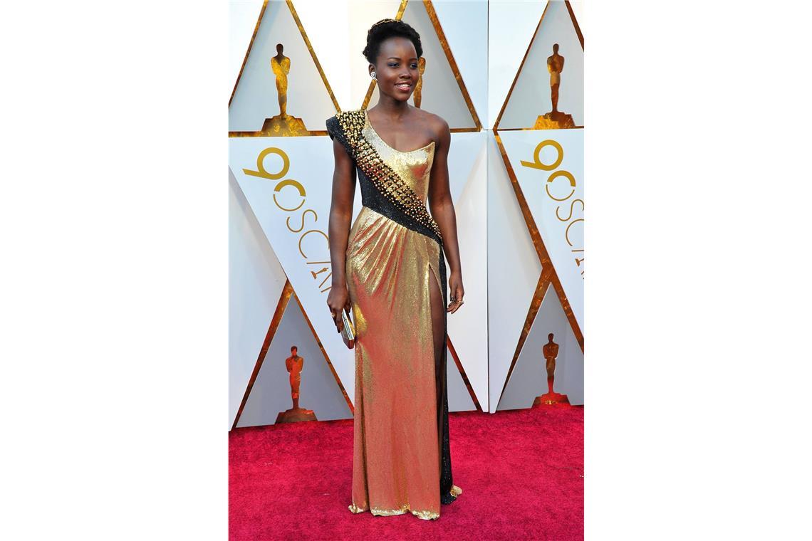 Hui oder pfui? An <b>Lupita Nyong’os</b> Gold-Robe von Atelier Versace schieden sich <b>2018</b> sicher die Geister. Die Anklänge an die 80er Jahre waren zumindest gewöhnungsbedürftig.