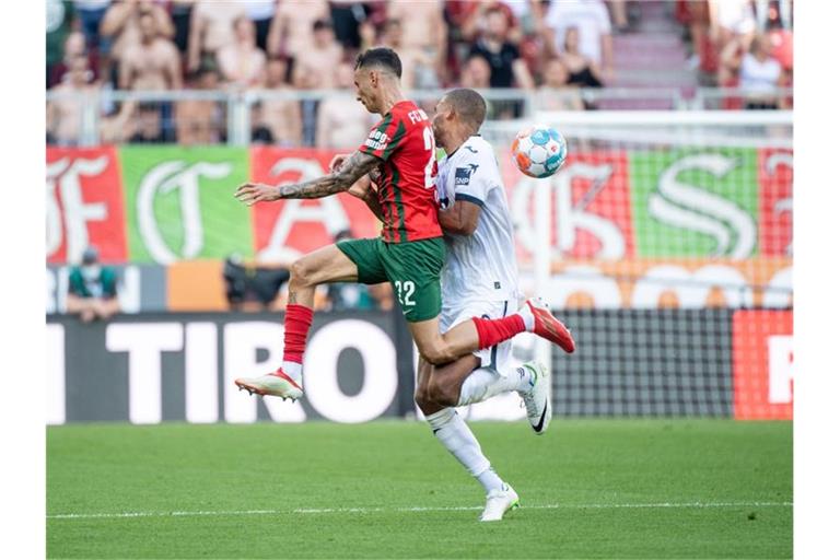 Iago von Augsburg (l) kollidiert im Zweikampf mit Kevin Akpoguma von Hoffenheim. Foto: Matthias Balk/dpa