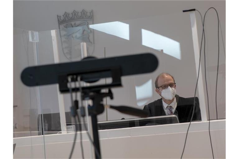 Im Arbeitsgericht sitzt Richter Nikolaus Zimmermann vor einer Webcam hinter einer Plexiglasscheibe. Foto: Stefan Puchner/dpa