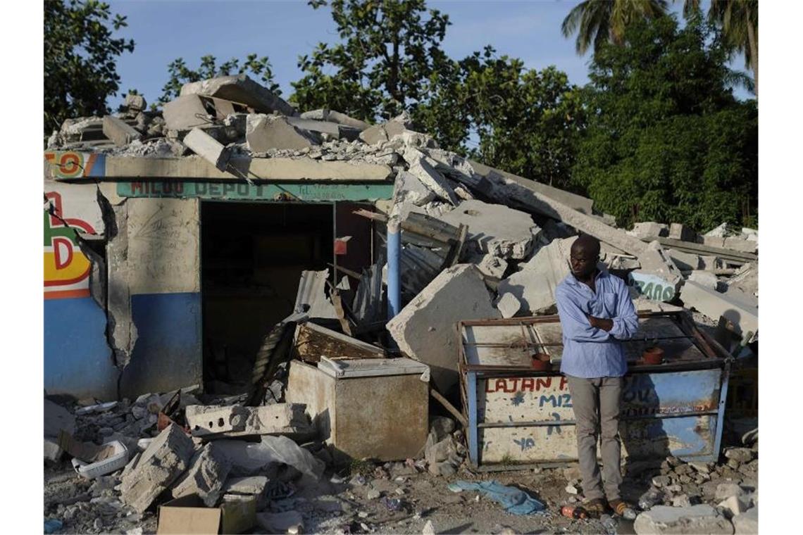 Erdbeben in Haiti: Fast 1300 Tote - Sturm nähert sich In Trümmern: Ein Mann steht vor einem eingestürzten Geschäft in Saint-Louis-du-Sud. Foto: Matias Delacroix/AP/dpa