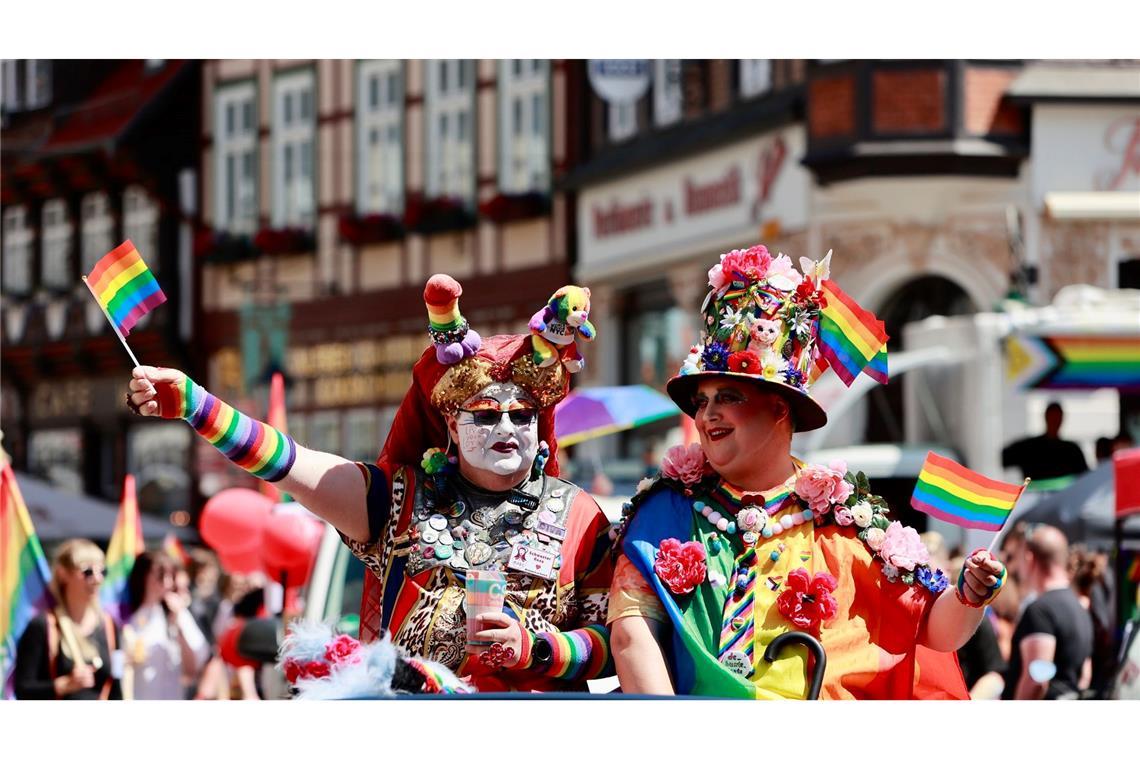 In Wernigerode, Sachsen-Anhalt, ziehen zahlreiche Teilnehmer beim Christopher Street Day durch die Stadt. So wie diese zwei Besucher, die sich per Auto dem Umzug anschließen.