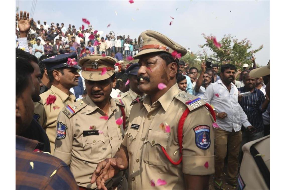 Indiens Polizei tötet Mordverdächtige - und bekommt Applaus Indische Polizisten bewachen ein Gebiet etwa 50 Kilometer von Hyderabad, in dem vier mutmaßliche Vergewaltiger von der Polizei erschossen wurden. Foto: Mahesh Kumar A/AP/dpa