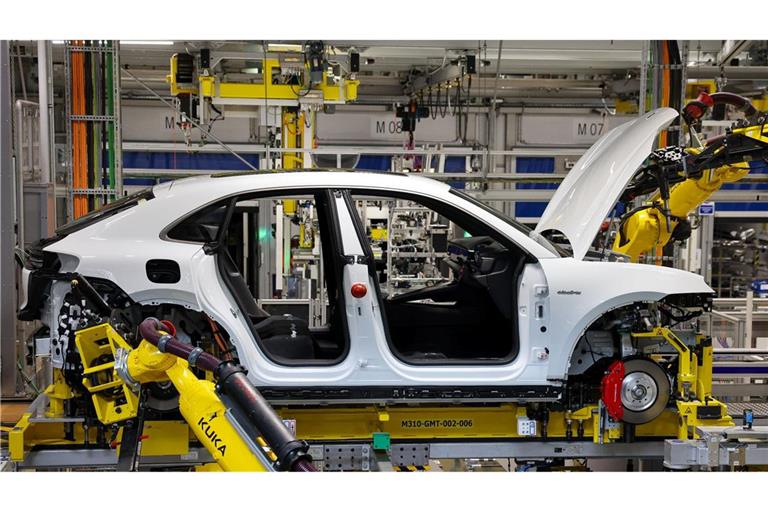 Industrieroboter arbeiten an einem vollelektrischen Porsche Macan.