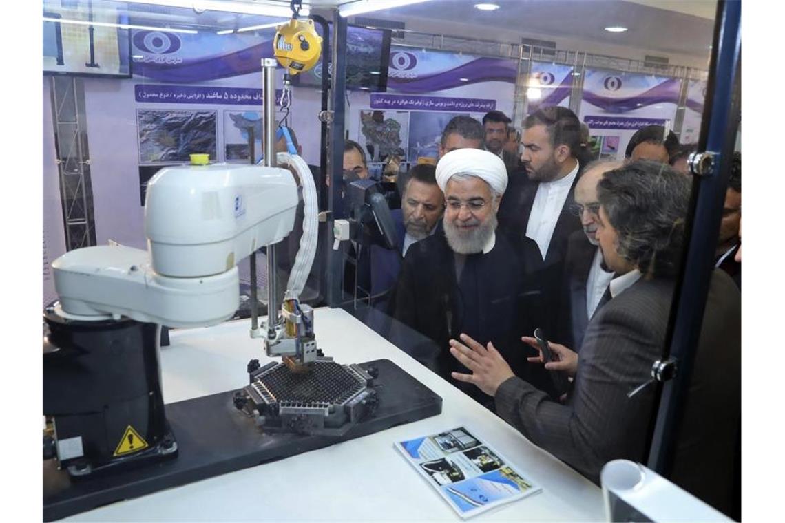 Irans Präsident Hassan Ruhani (M.) lässt sich neue Entwicklungen in der atomenergie im Rahmen des „Nationalen Atomtags“ erklären. Foto: Uncredited/Iranian Presidency Office/AP/dpa