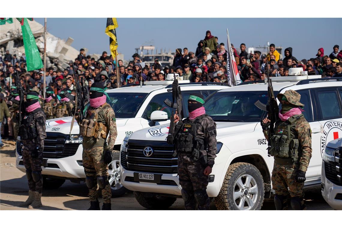 Islamisten umstellen Autos des Roten Kreuzes.