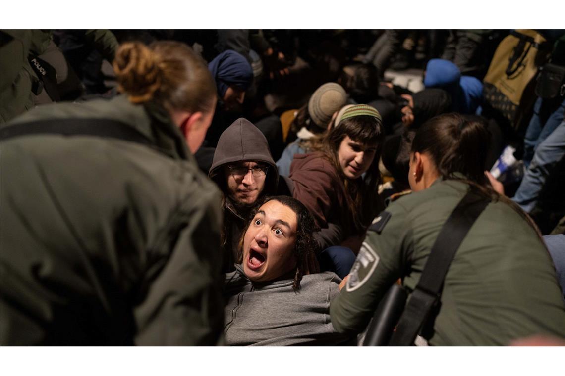 Israelische Beamte entfernen rechte Aktivisten, die während einer Demonstration in Jerusalem gegen die Waffenruhe zwischen Israel und der Hamas eine Straße blockieren.