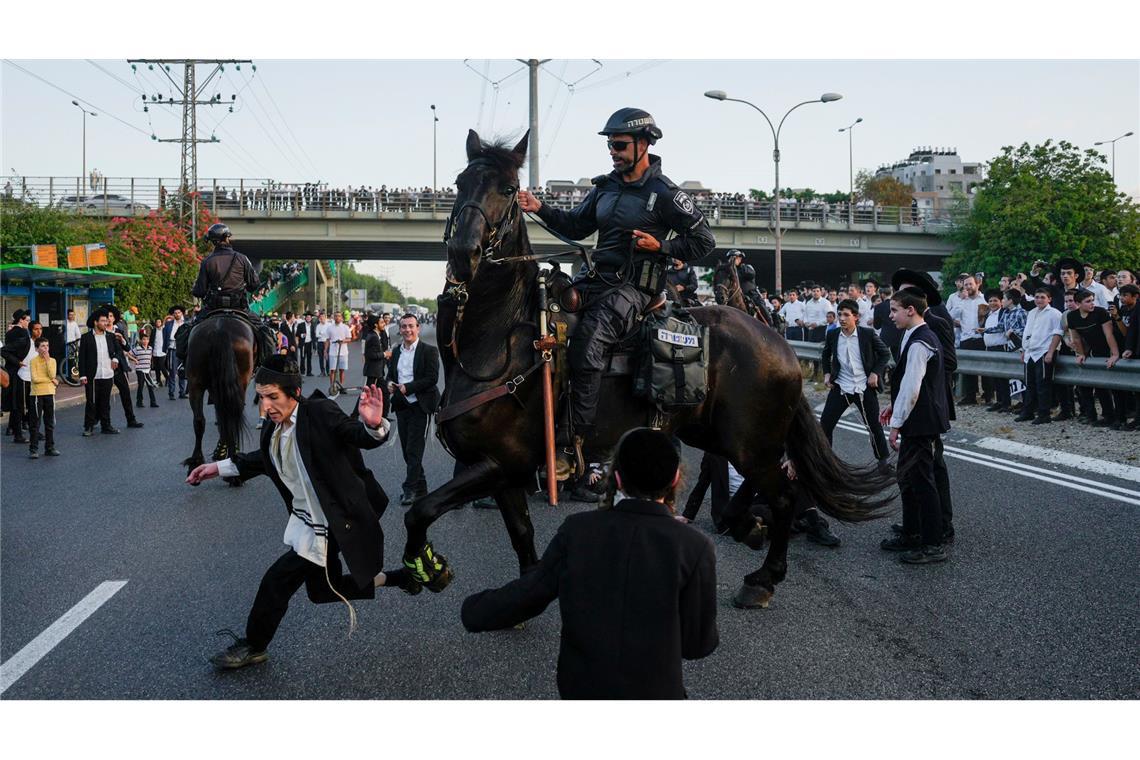 Israelische berittene Polizei vertreibt ultraorthodoxe Juden, die eine Straße blockieren, während eines Protests gegen die Rekrutierung zum Militär.