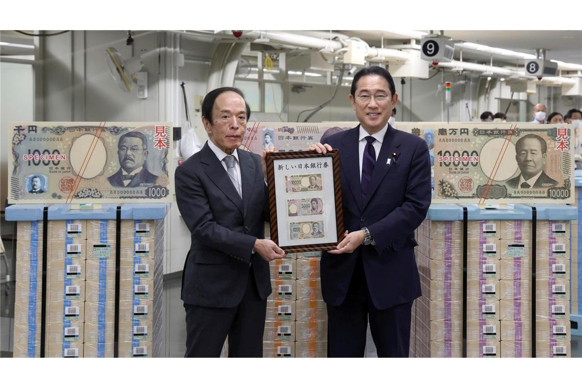 Japans Premierminister Fumio Kishida (r) und der Gouverneur der Bank of Japan, Kazuo Ueda, präsentieren die neuen Banknoten in Tokio.