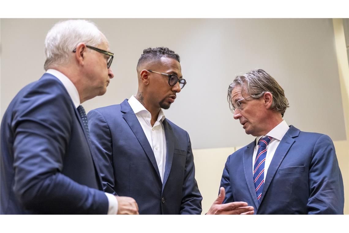 Jerome Boateng (M) im Gerichtssaal mit seinem Anwalt Leonard Walischewski (r) und Sprecher Thomas Knipp (l).