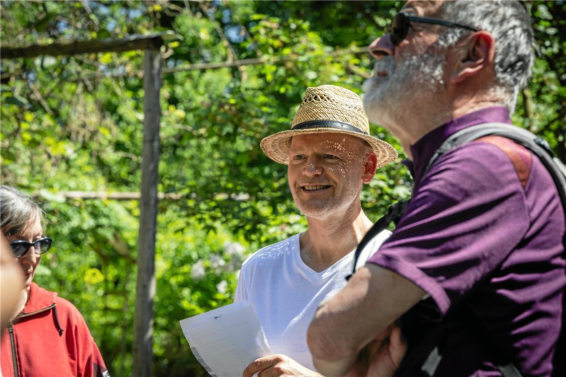 Joachim Jung (Mitte)  führt durch den Garten der Familie in Unterweissach.