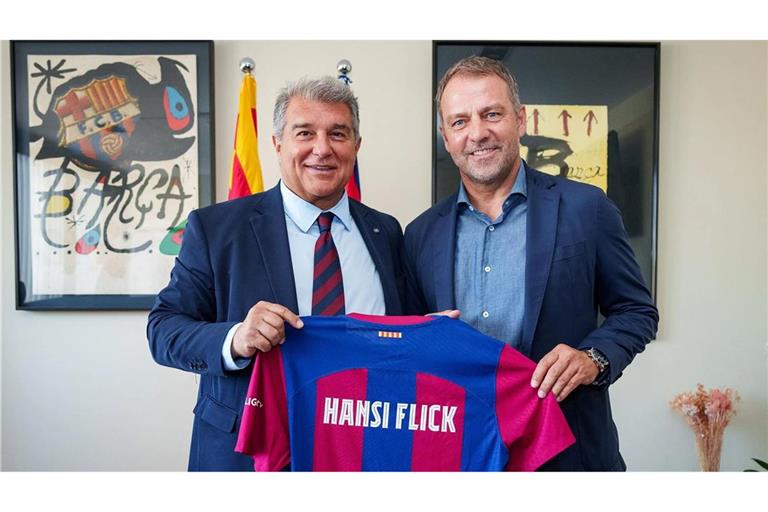 Joan Laporta (l), Präsident vom FC Barcelona, und Hansi Flick halten das Barca-Trikot. Der Beginn der Ära Flick verzögert sich bei den Katalanen (Archivfoto).