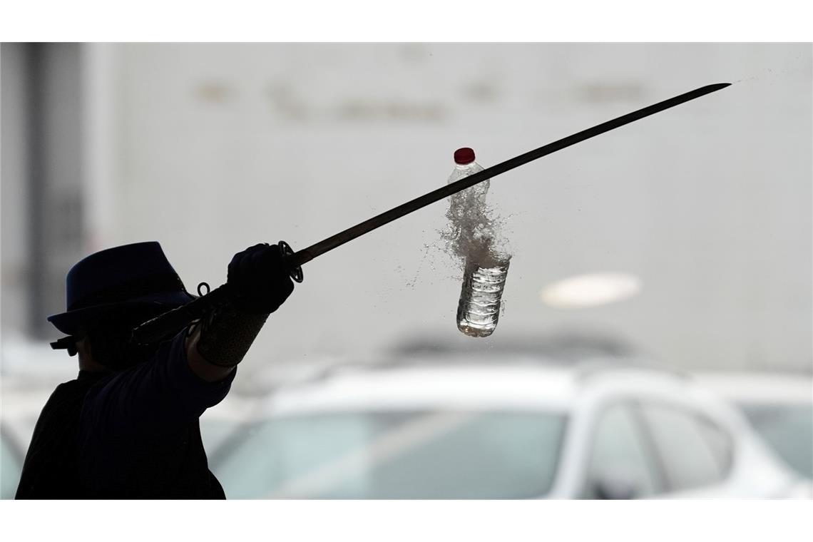 Joe Alexander zerteilt mit verbundenen Augen und einem Samurai-Schwert hochgeworfene Wasserflaschen, während des Weltrekordversuchs im Elbtor in der Hamburg Altona VW Niederlassung. Die Rekordversuche finden in Rahmen des siebzigsten Guinness World Records Day statt.