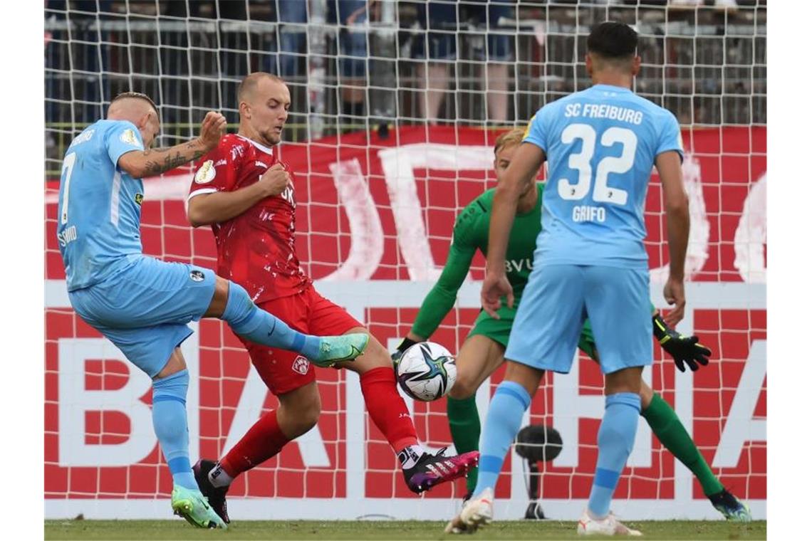 Jonathan Schmid (l) vom SC Freiburg schießt den Ball ins Tor zum Treffer zum 0:1. Foto: Daniel Karmann/dpa