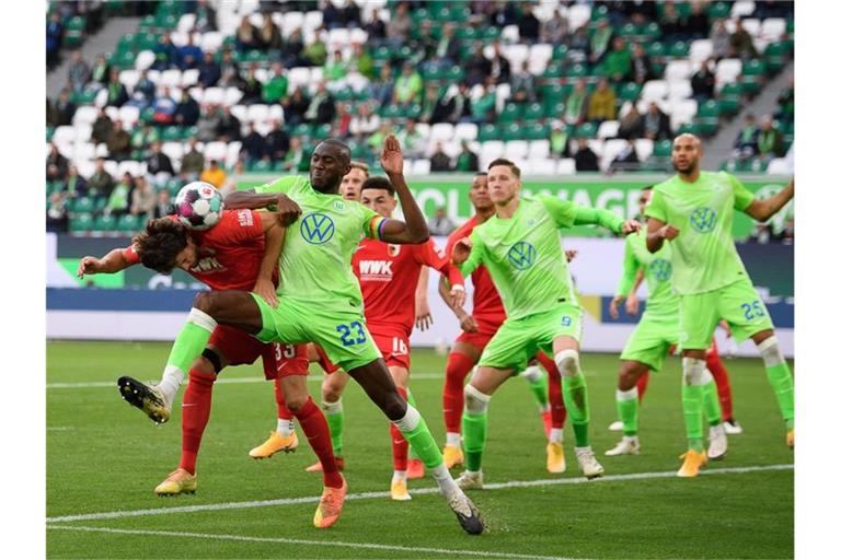 Josuha Guilavogui (3.v.l.) vom VfL Wolfsburg und Tobias Strobl, Spieler beim FC Augsburg, kämpfen um den Ball. Foto: Swen Pförtner/dpa