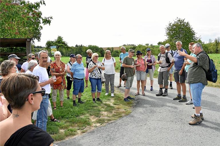 Jürgen Seibold (rechts) macht mit den Teilnehmern des Krimispaziergangs Station am Pfarrgütle in Rietenau. Foto: Tobias Sellmaier