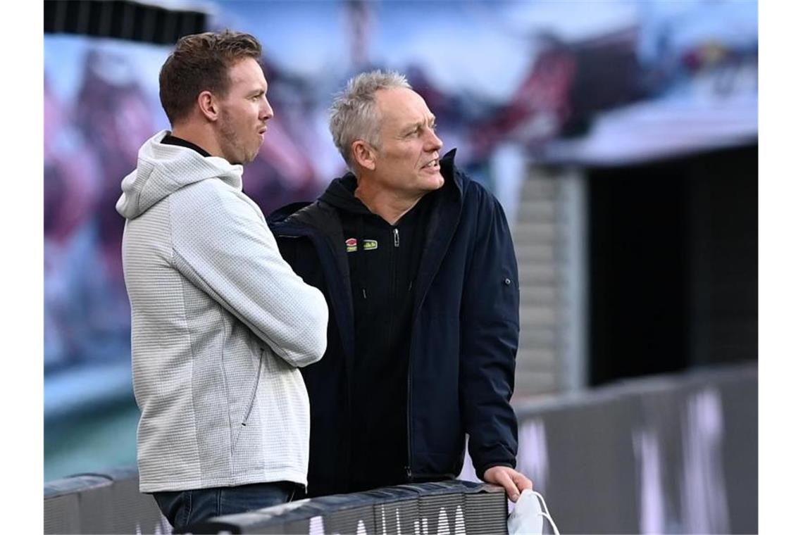 Julian Nagelsmann (l) und Christian Streich unterhalten sich im Stadion. Foto: Hendrik Schmidt/dpa-Zentralbild/ZB/Archivbild