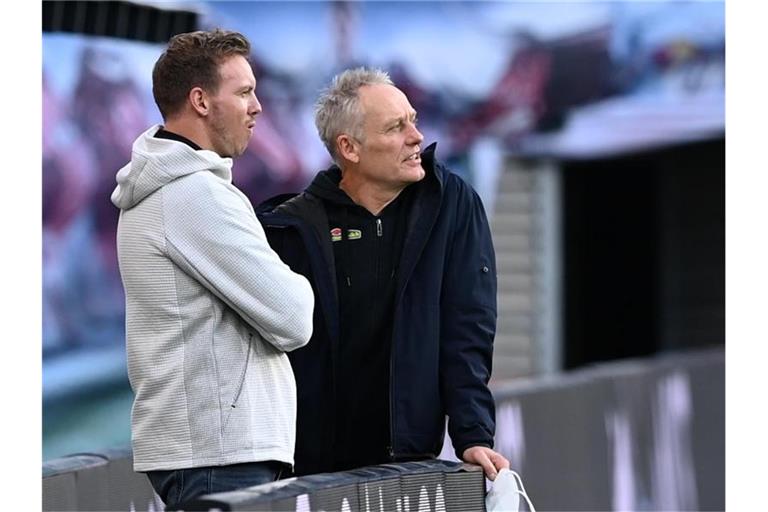 Julian Nagelsmann (l) und Christian Streich unterhalten sich im Stadion. Foto: Hendrik Schmidt/dpa-Zentralbild/ZB/Archivbild