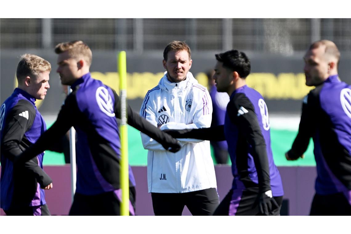 Julian Nagelsmann (M) beobachtet das Aufwärmen seiner Spieler.