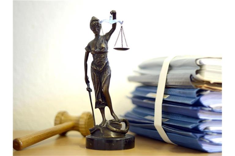 Justitia mit Holzhammer und Aktenstapel. Foto: Volker Hartmann/dpa/Symbolbild