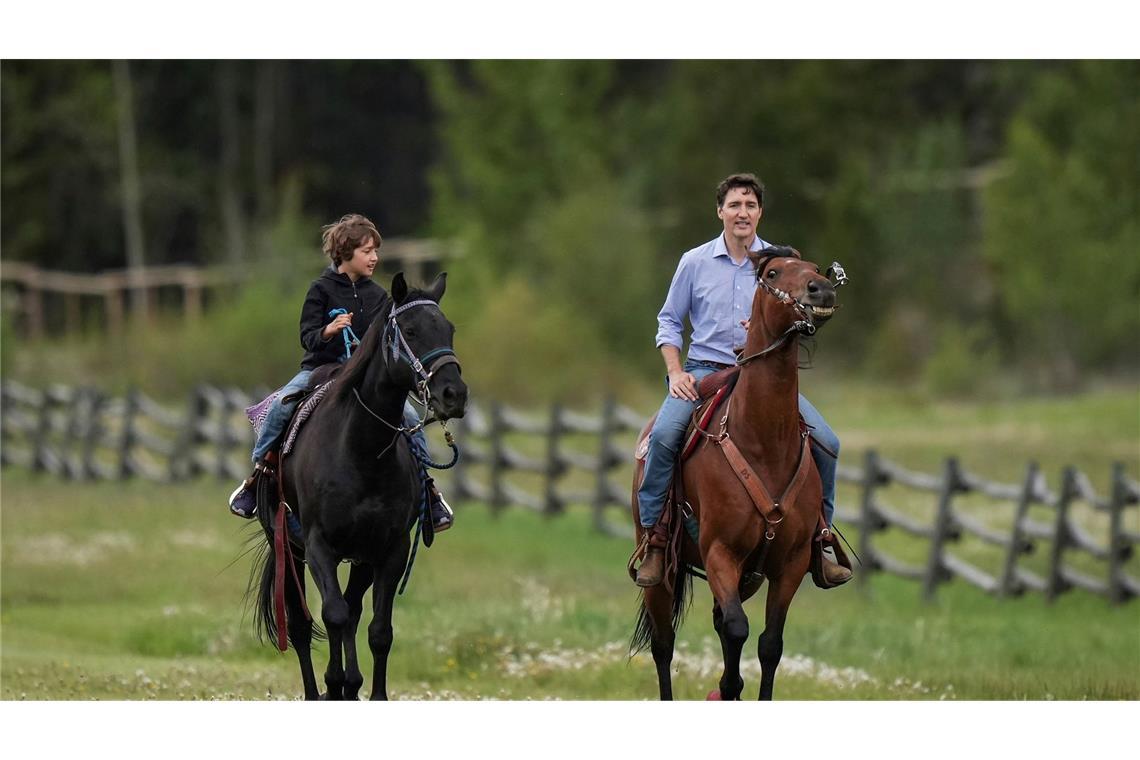 Kanadas Premierminister Justin Trudeau und sein Sohn Hadrien reiten auf Pferden im kanadischen Nemaiah-Tal.