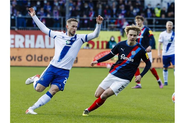 Karlsruhes Christoph Kobald (l) und Kiels Finn Porath kämpfen um den Ball. Foto: Frank Molter/dpa