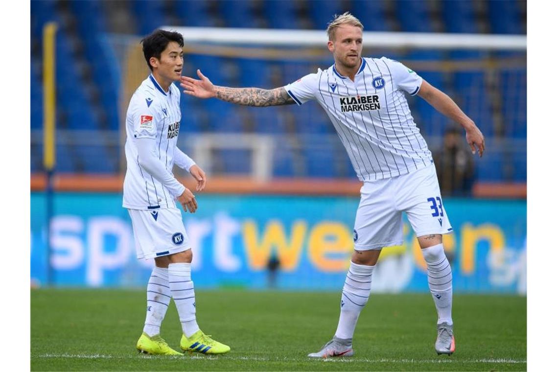 Karlsruhes Kyoung-Rok Choi (l) jubelt nach einem Tor mit Philipp Hofmann. Foto: Swen Pförtner/dpa/Archivbild