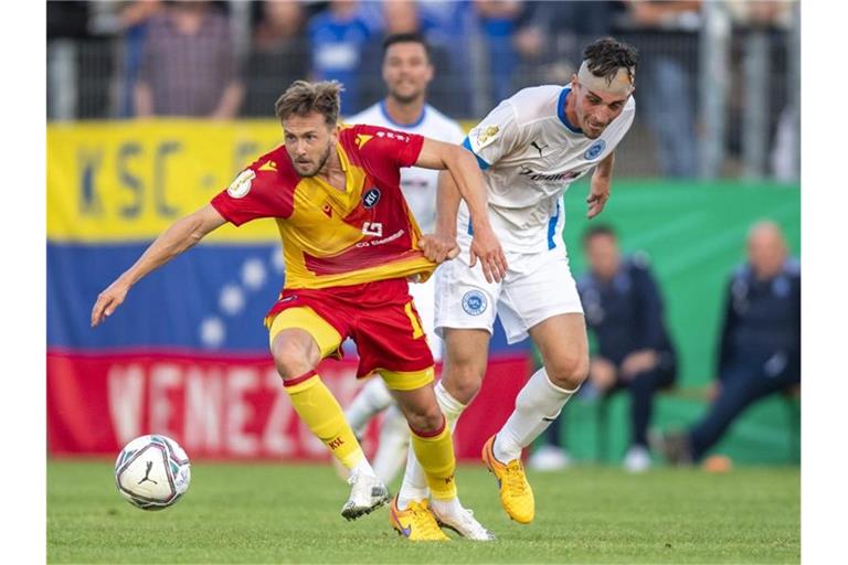 Karlsruhes Lucas Cueto (l) und Lottes Luis Allmeroth kämpfen um den Ball. Foto: David Inderlied/dpa