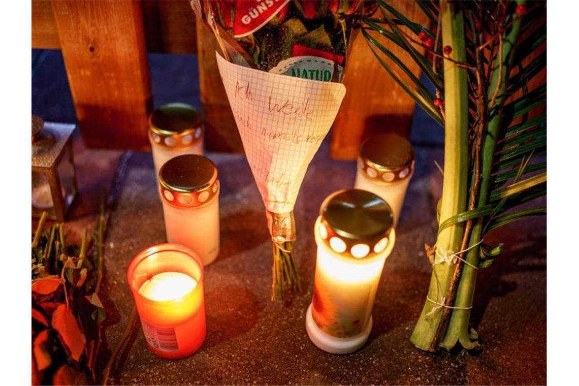 Obduktionsergebnis zum Fall Glinde: Vater gab Schüsse ab Kerzen, Blumen und ein Blumenstrauß stehen vor dem Eingang zu dem Haus, in dem am zweiten Weihnachtstag drei Menschen einer vierköpfigen Familie tot gefunden wurden. Foto: Axel Heimken/dpa