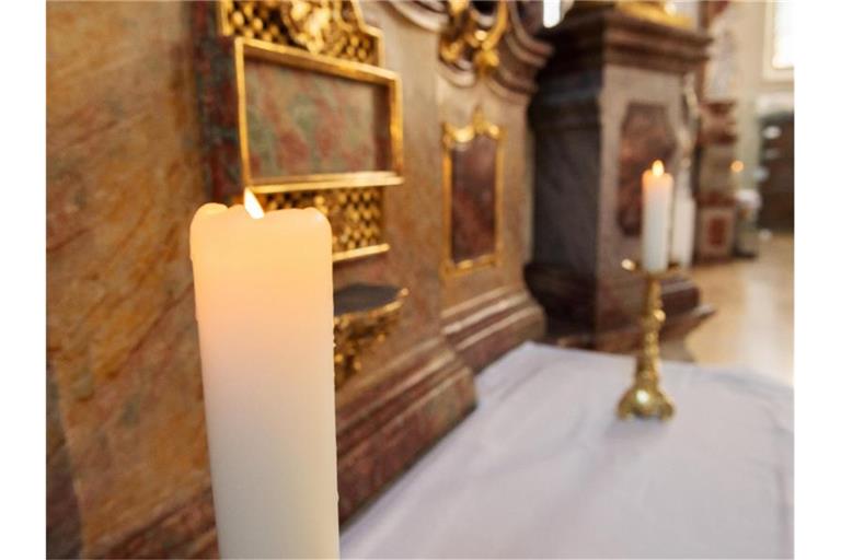 Kerzen brennen vor dem Sonntagsgottesdienst. Foto: Silas Stein/dpa/Symbolbild