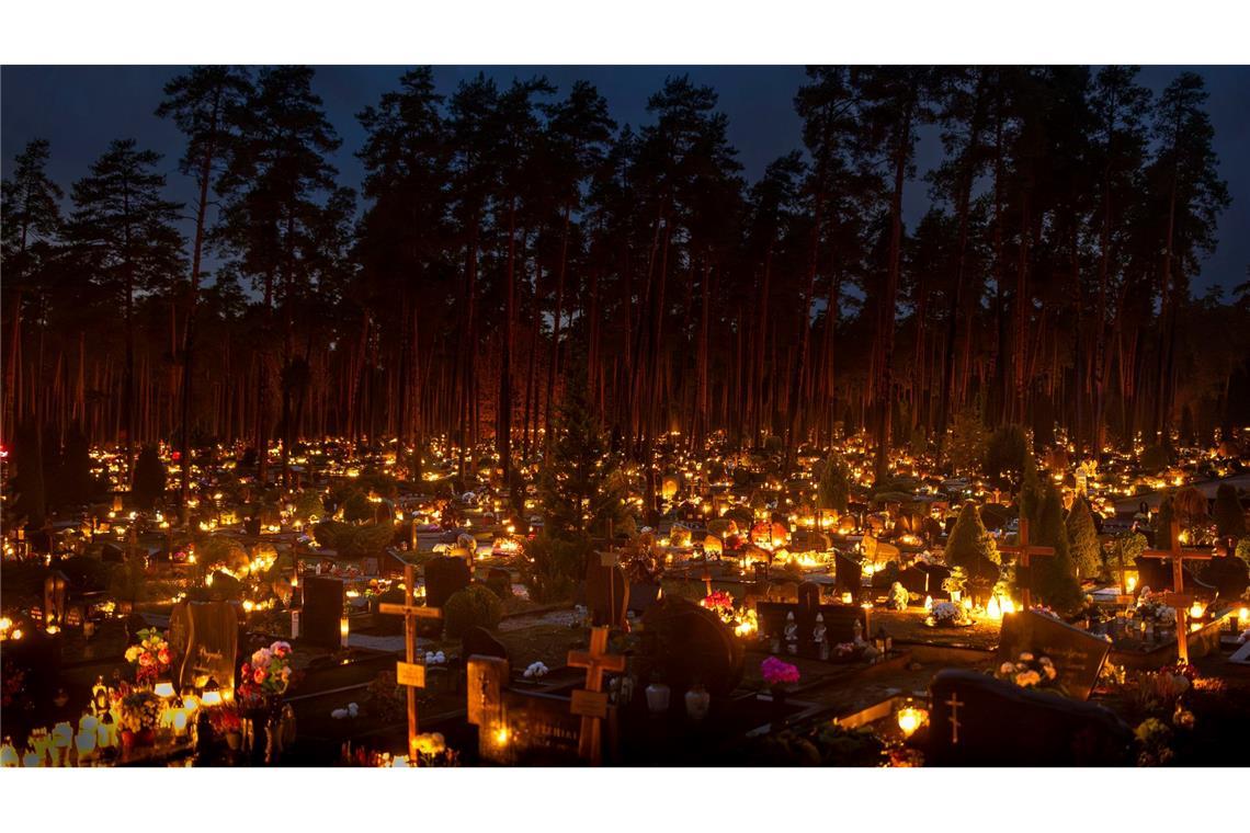 Kerzen leuchten an Allerheiligen auf einem Friedhof in der Hauptstadt.