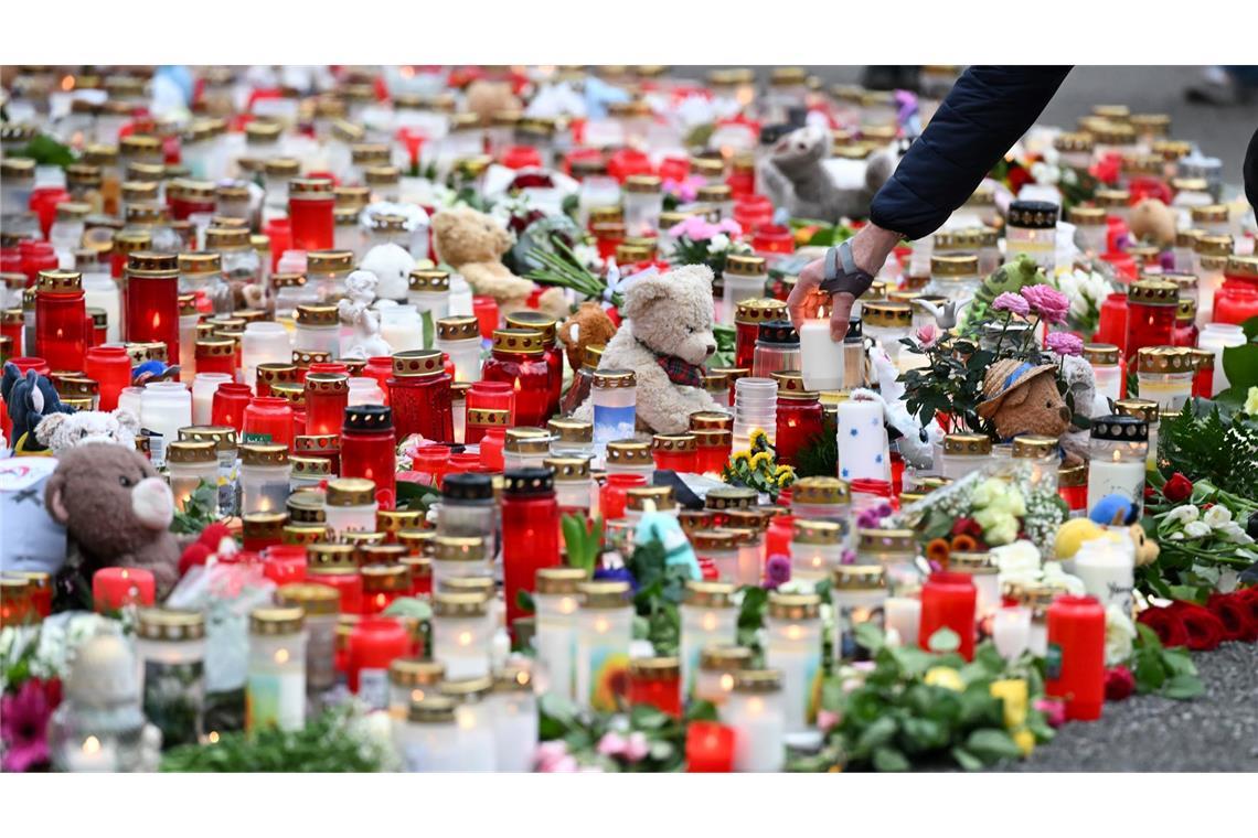 Kerzen und Blumen werden nach dem tödlichen Angriff in einem Park in Aschaffenburg niedergelegt.