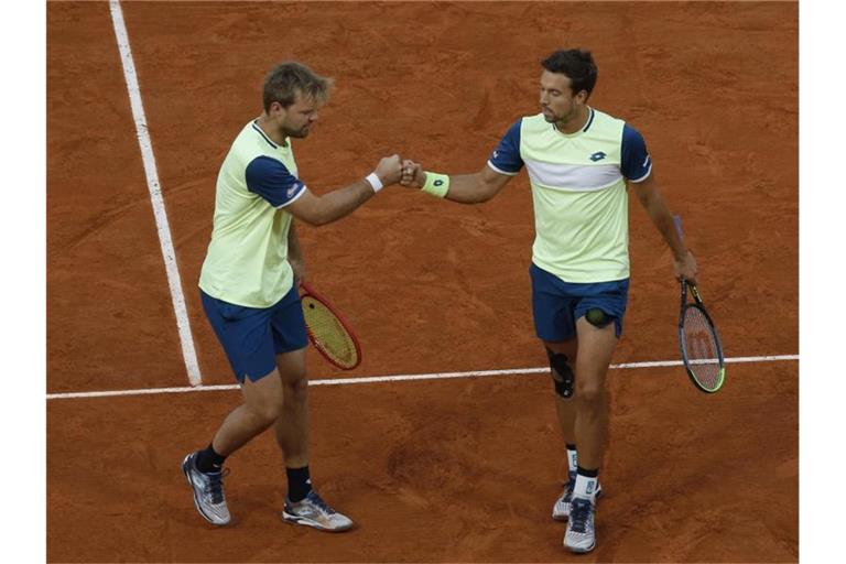 Kevin Krawietz (l) und Andreas Mies klatschen sich nach einem Ballwechsel ab. Foto: Michel Euler/AP/dpa