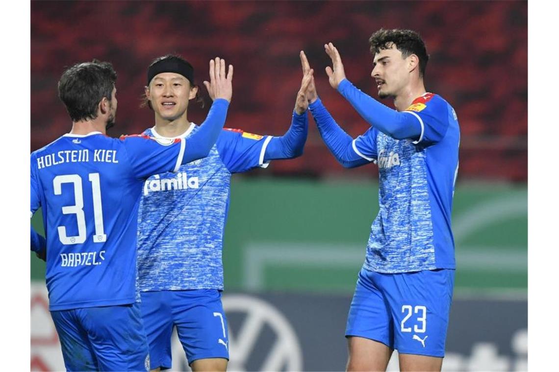 Kiel will gute Ausgangsposition in Heidenheim festigen Kiels Janni Luca Serra (r) bejubelt sein Tor mit Fin Bartels (l) und Jae-Sung Lee. Foto: Martin Meissner/AP POOL/dpa