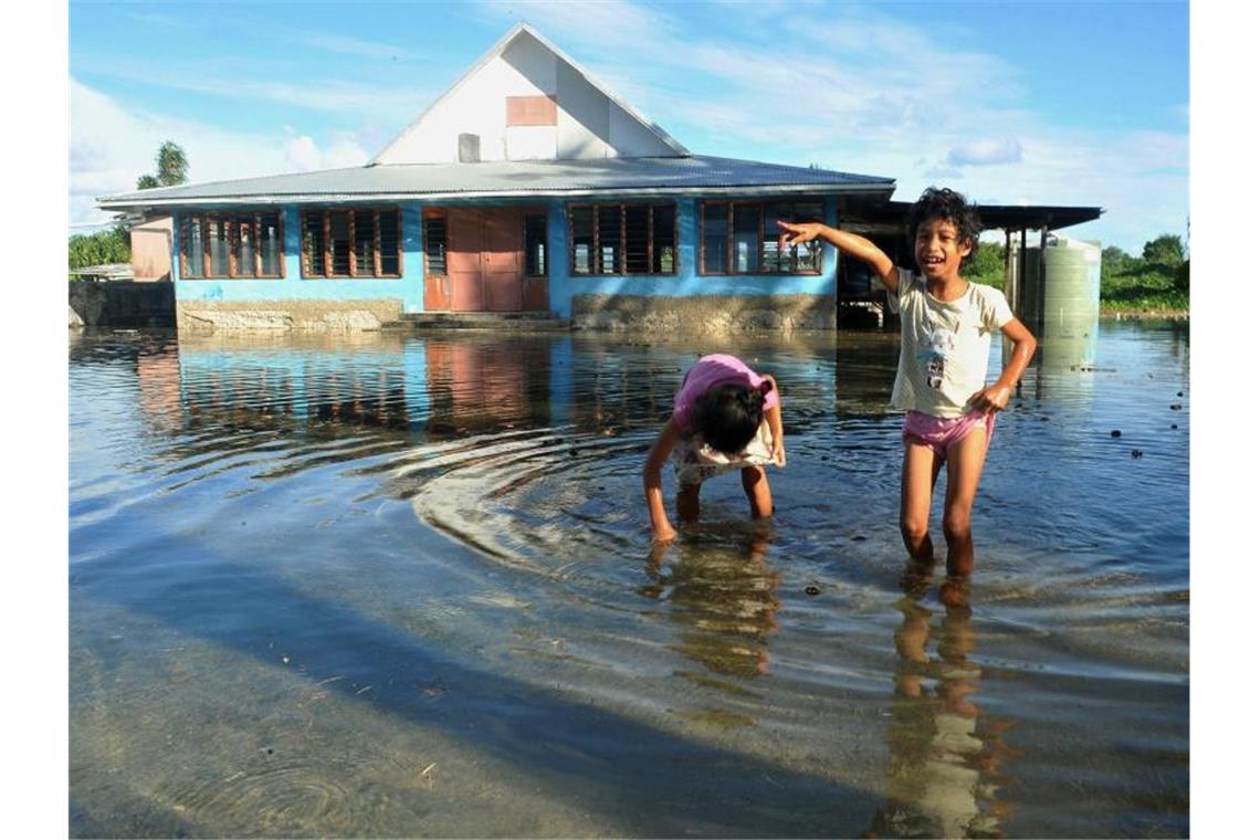 Klimatrend setzt sich fort: 2019 wohl zweitheißestes Jahr Kinder spielen auf einem vom Meerwasser überflutetem Platz in Funafuti, der Hauptstadt des pazifischen Inselstaats Tuvalu. Foto: Kyodo/epa/dpa/Archiv