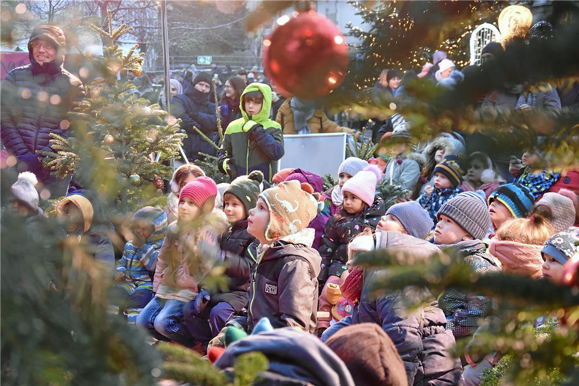 Kinder und Familien lauschen der Kasperlegeschichte von Professor Pröpstls Puppentheater auf der Waldbühne im Stiftshof, die liebevoll mit einem kleinen Weihnachtsbaumwald für Klein und Groß geschmückt ist.